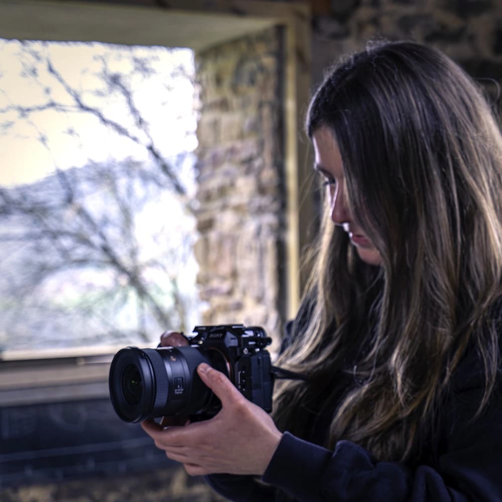 Videógrafa revisando la cámara durante un rodaje dentro de la obra